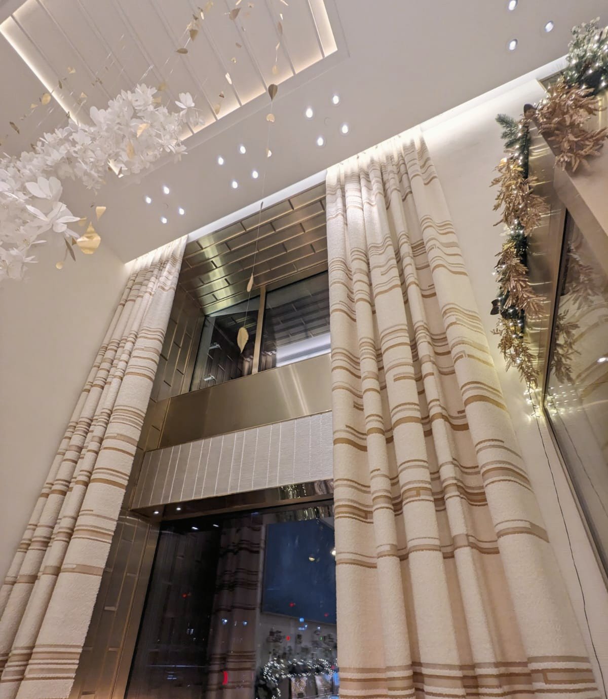 Hôtel de luxe à Paris, pose de rideaux rayés crème en grande hauteur